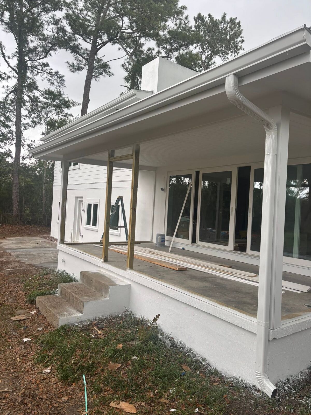 Fresh white gutter run wrapping a covered porch on new construction