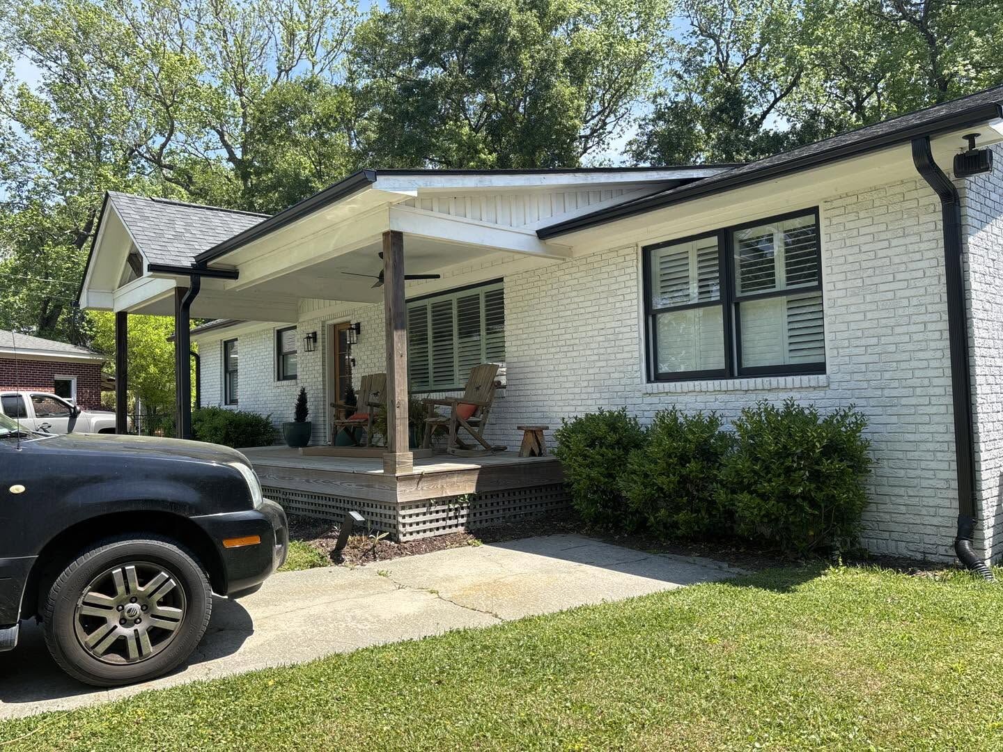 Seamless black gutters installed on a painted-brick home in the Charleston area